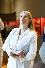 Woman standing and looking at art objects in museum of  history arts