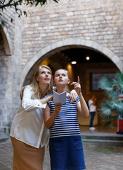 Woman with daughter using guide and walking near museum of  history arts  outdoor
