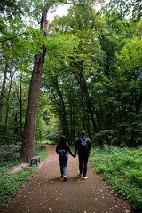 Fototapeta premium young couple walking by city park holding hands