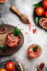 Blood orange juice with ice and orange slice. Fresh summer cocktail with red oranges in a glass. Fresh cocktail. Nonalcoholic blood orange cocktail in a glass.