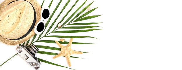 Flat lay traveler accessories: tropical palm leaf, retro camera, straw hat, fashion sunglasses,...