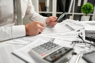 Businessman working at office and calculating finance, reads and writes reports. Business financial accounting concept.