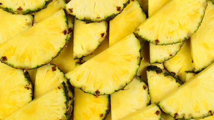Pineapple juicy yellow slices background. Top view.