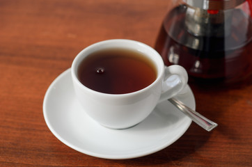 White cup of tea on a wooden table. Tea party concept, break.
