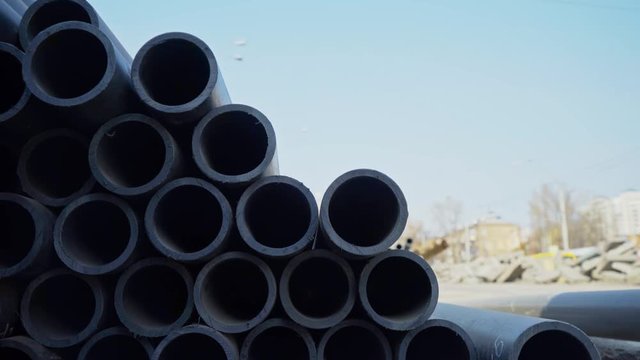 warehouse of plastic pipes in the open. water pipes. construction of the city. water supply. black plastic.
