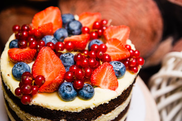 delicious biscuit cake with a topping of lots of berries close up