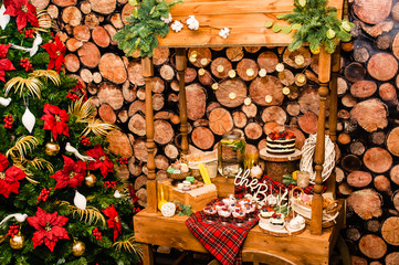 Christmas tree near a table with sweets in new year decoration