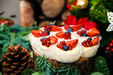 delicious cupcakes with different berries in Christmas decoration