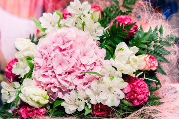 bouquet of tender and bright pink and white flowers with green leaves