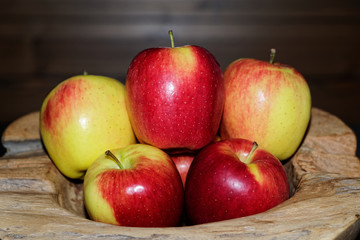 Close-up of ripe red yellow apples in a wooden bowl