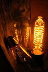 Cobbled classic incandescent Edison light bulbs with visible glowing wires in the night