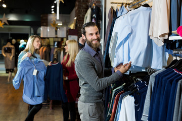 Man chooses a shirt in the store. Sale, shopping, fashion, style and people concept