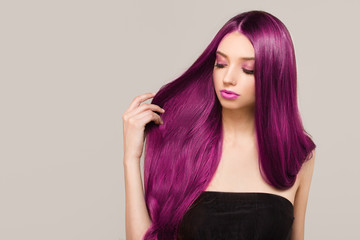 Woman with purple bright hair color. Shades of pink. Straight shiny hair
