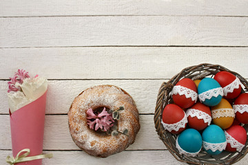  Wielkanocne tło - kolorowe pisanki w koszyku, babka wiekanocna i wiosenne kwiaty