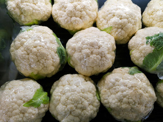 Cauliflowers in plastic wrap on shelves in the supermarkets,market.