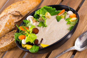 Cream soup  with shitake mushroom served with vegetables and greens