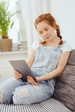 Young woman sitting reading on a tablet