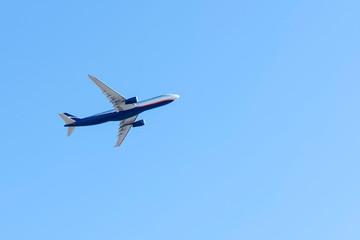 flying airplane in a cloudless blue sky