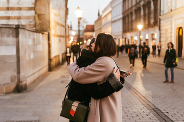 Close-up photo of two emotional woman friends hugging each other