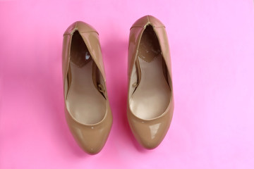 Trendy glamour fancy beige nude pink patent glossy pair of elegant  high heeled shoes on pink background
