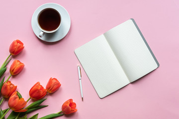 Notebook cup of tea and tulips on pink background. Place for your texy