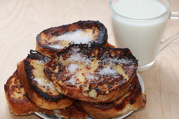 Roasted bread and a mug of milk on a wooden table close-up, tasty breakfast and a good start to the day, national Russian cuisine