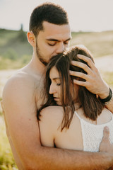 Naklejka premium Stunning brunette hugs naked man and holds her hands on his back