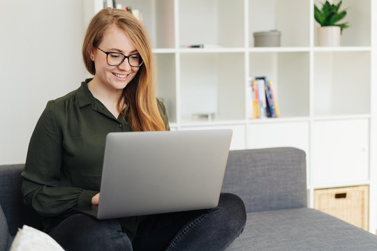 Smiling young woman relaxing with her laptop