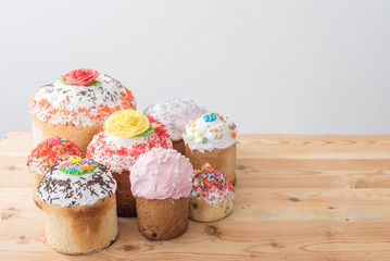 beautiful Easter cakes with raisins in colored glaze on a wooden table