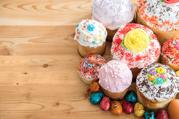 top view Russian Easter cakes in glaze and decorations on wooden table with quail colored eggs