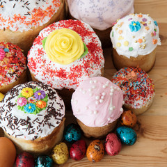 Russian Easter cakes in glaze and decorations on a wooden table with quail colored eggs