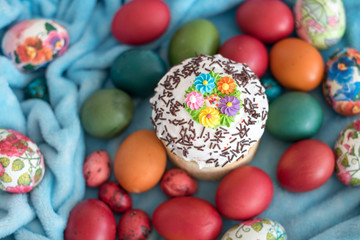 Fototapeta na wymiar Easter composition with kulich in white glaze and eggs on a blue background