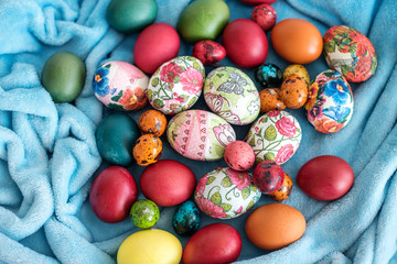 many colorful Easter eggs in a nest of blue plaid