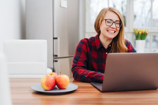 Healthy grinning young woman working on a laptop