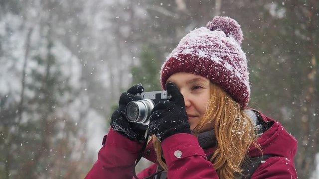 Woman backpacker in a winter hike snow forest trail national par Young girl enjoy snow falling . Happy winter holidays active lifestyle concept.