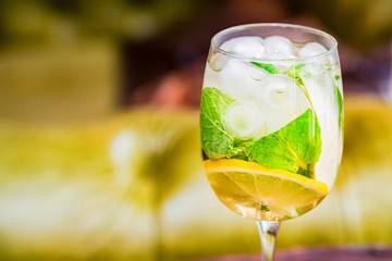 Glass with delicious fresh homemade mojito on blurred background