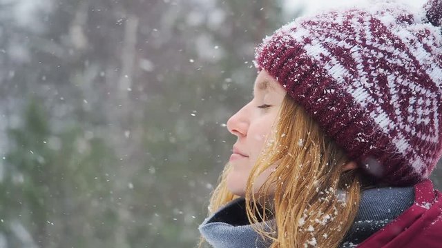 Woman backpacker in a winter hike snow forest trail national par Young girl enjoy snow falling . Happy winter holidays active lifestyle concept.