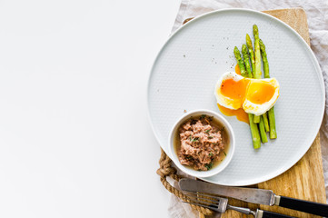 Mini grilled asparagus with egg and tuna. White background, top view, space for text.