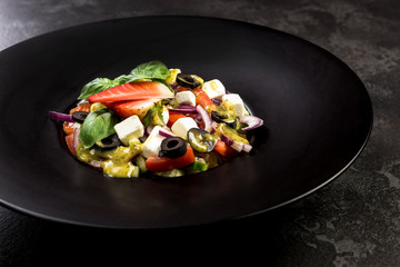 Healthy salad on dark plate.Restaurant dish,healthy eating