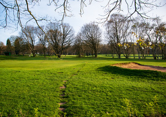 A golf field in the rural England observed from the public area