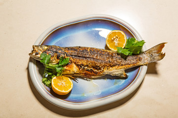 Grilled trout fish served with lemon on a plate
