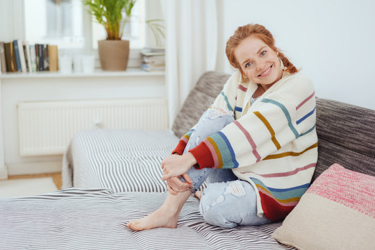 Pretty barefoot woman in a colorful winter jumper