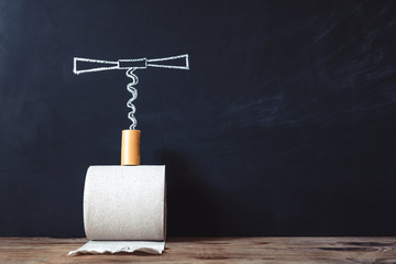 Constipation concept. Roll of toilet paper and a corkscrew on the background of chalk board