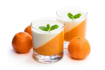 Panna cotta with orange jelly in clear glass isolated on white