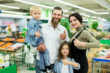 Portrait of a young family with a son and daughter in a supermarket.
