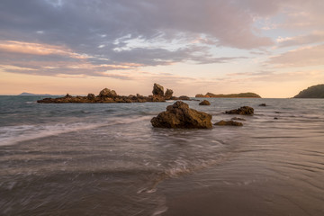 Fototapeta na wymiar Der Strand am Cape Hillsborough bei Sonnenuntergang mit buntem Himmel und vielen Wolken