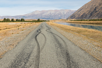 Fototapeta na wymiar rural asphalt road with black tyre skidding marks and copy space