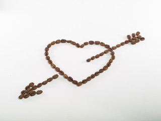 Concept of coffee beans in the form of heart on a white background. Valentine's Day. Enamored. Top view. Copy space
