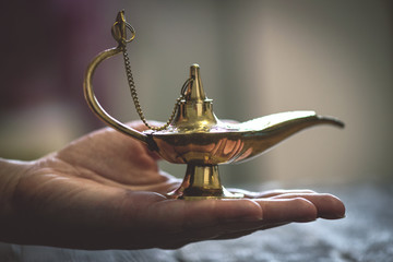 Magic lamp on the woman palm. Make a wish concept.