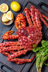 Red king crab on gray background. King crab, lemon and cilantro, top view © lblinova